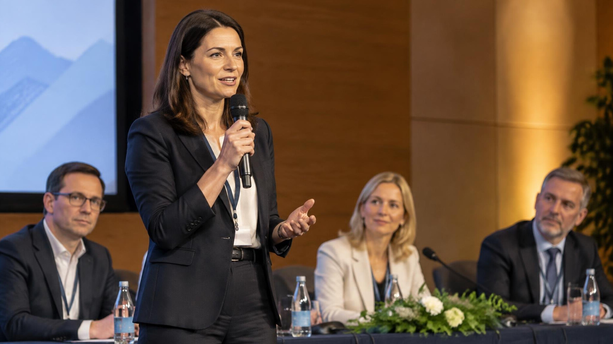 Moderator speaking into a microphone during a panel discussion